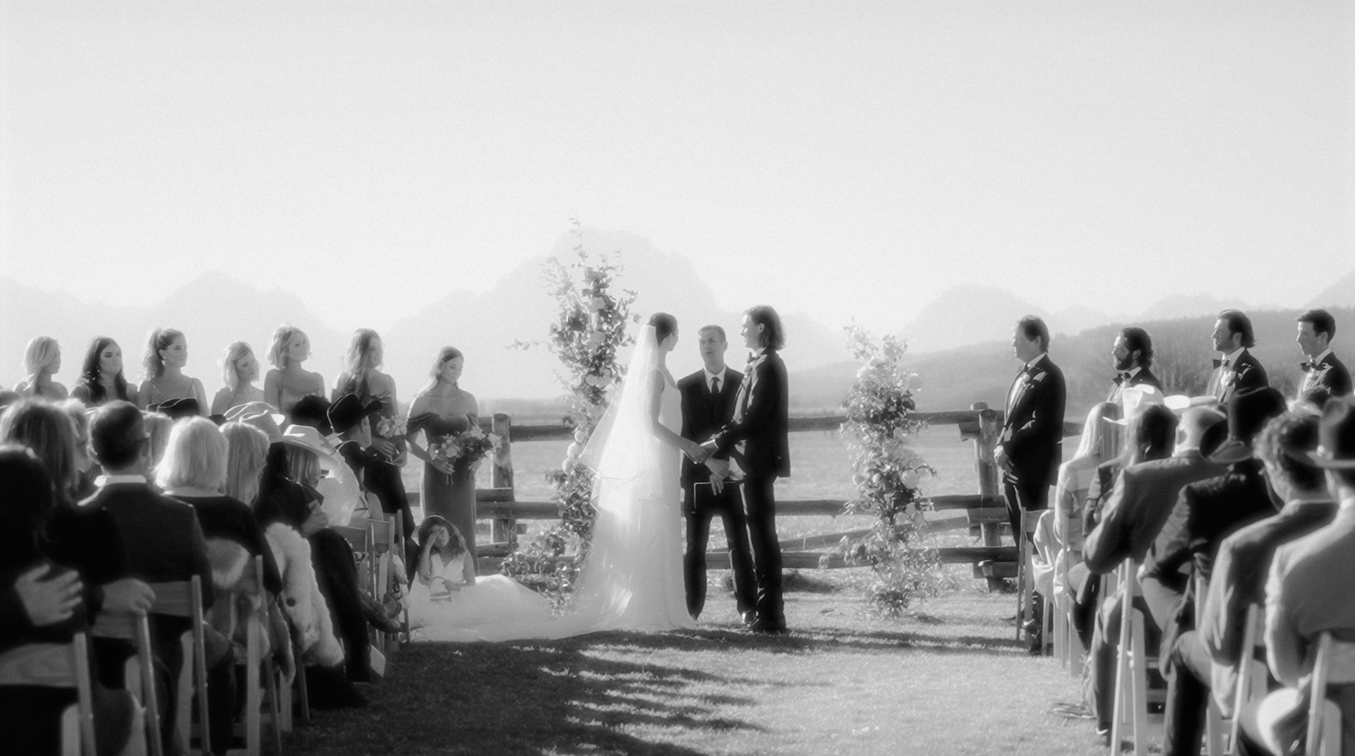 Guests watching a wedding
ceremony in black and white.