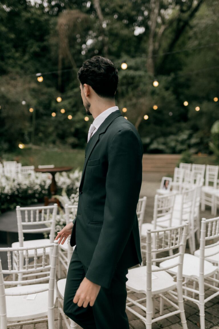 Event operations lead in a dark suit overseeing a ceremony setup before guests arrive